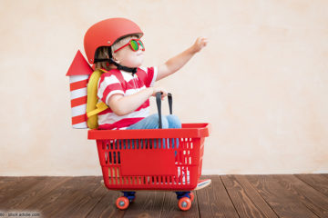 Kind sitzt in Einkaufswagen