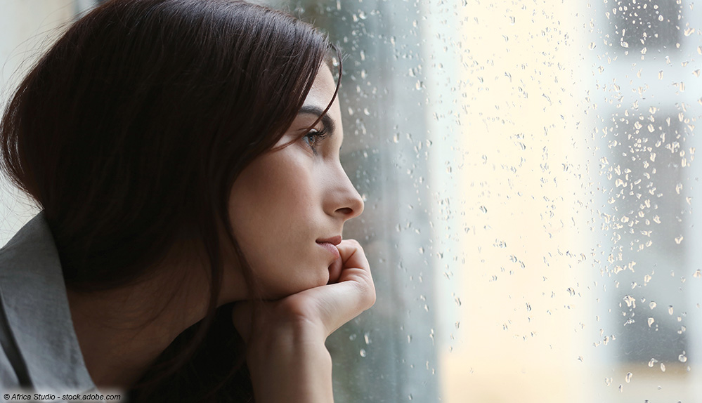 Traurige Frau am Fenster