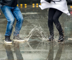 Ein Paar springt in eine Pfütze
