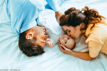 Vater und Mutter im Bett mit Baby