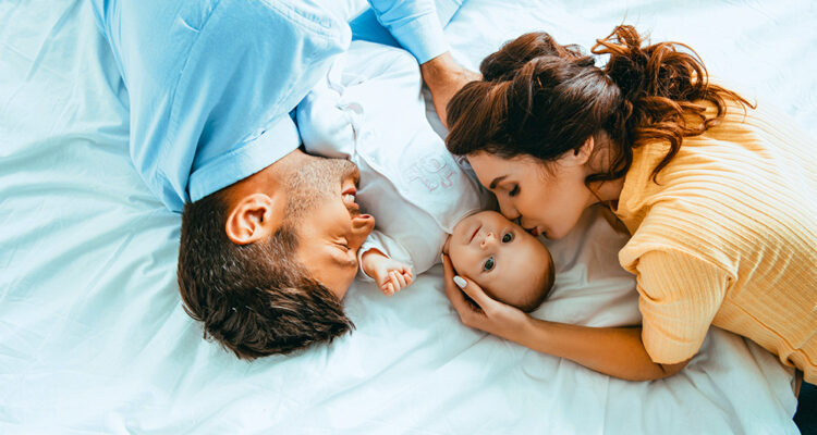 Vater und Mutter im Bett mit Baby