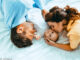 Vater und Mutter im Bett mit Baby