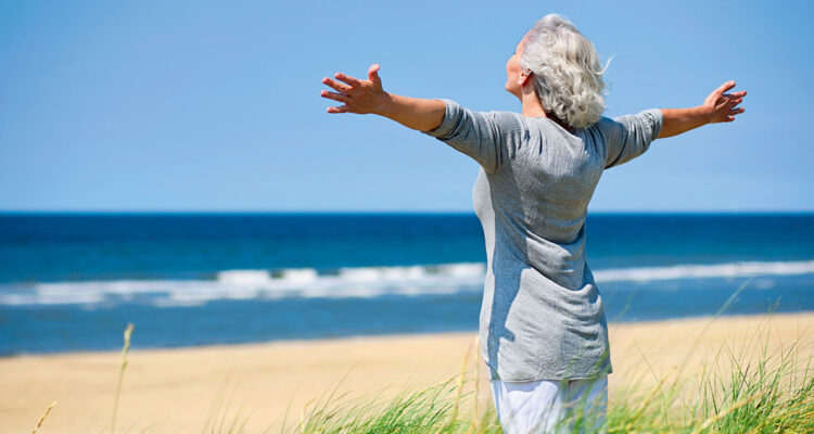 stehende Frau am Sandstrand am Meer