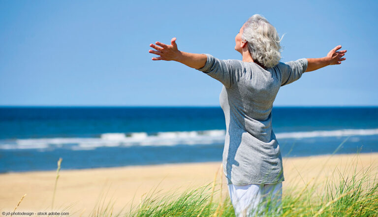 stehende Frau am Sandstrand am Meer