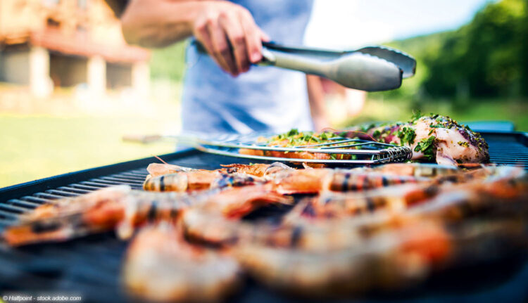 Grill mit Grillgut und Grillzange